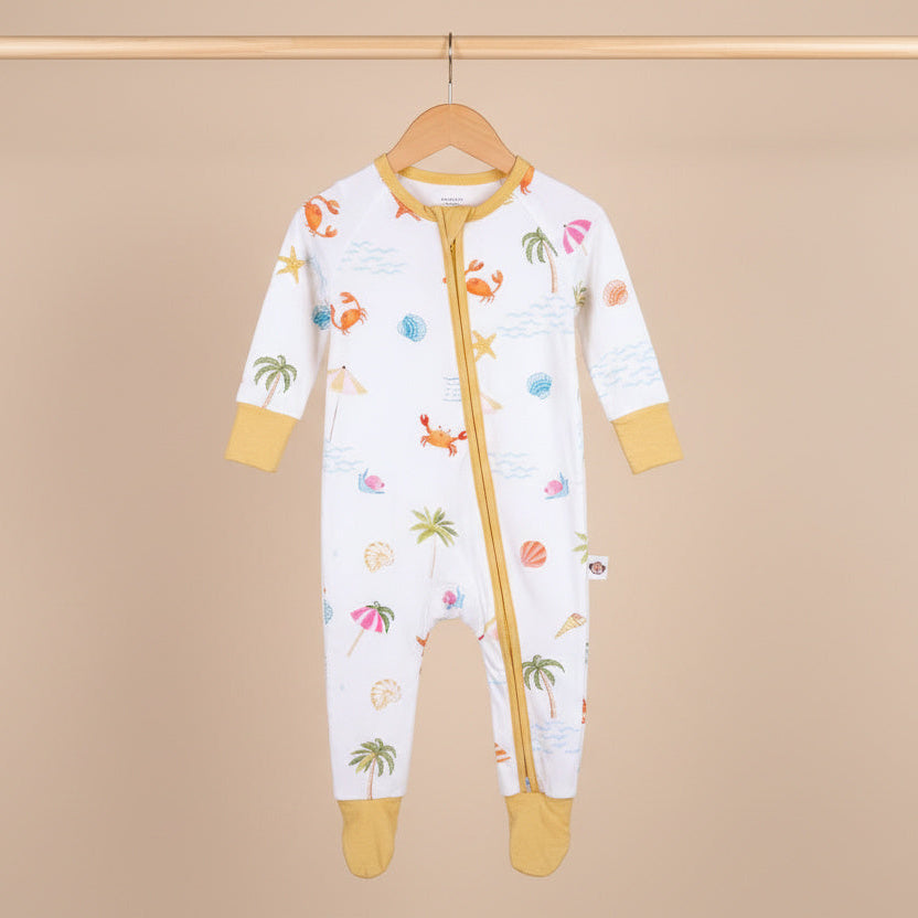 Baby onesie with colorful patterns on a wooden hanger against a beige background