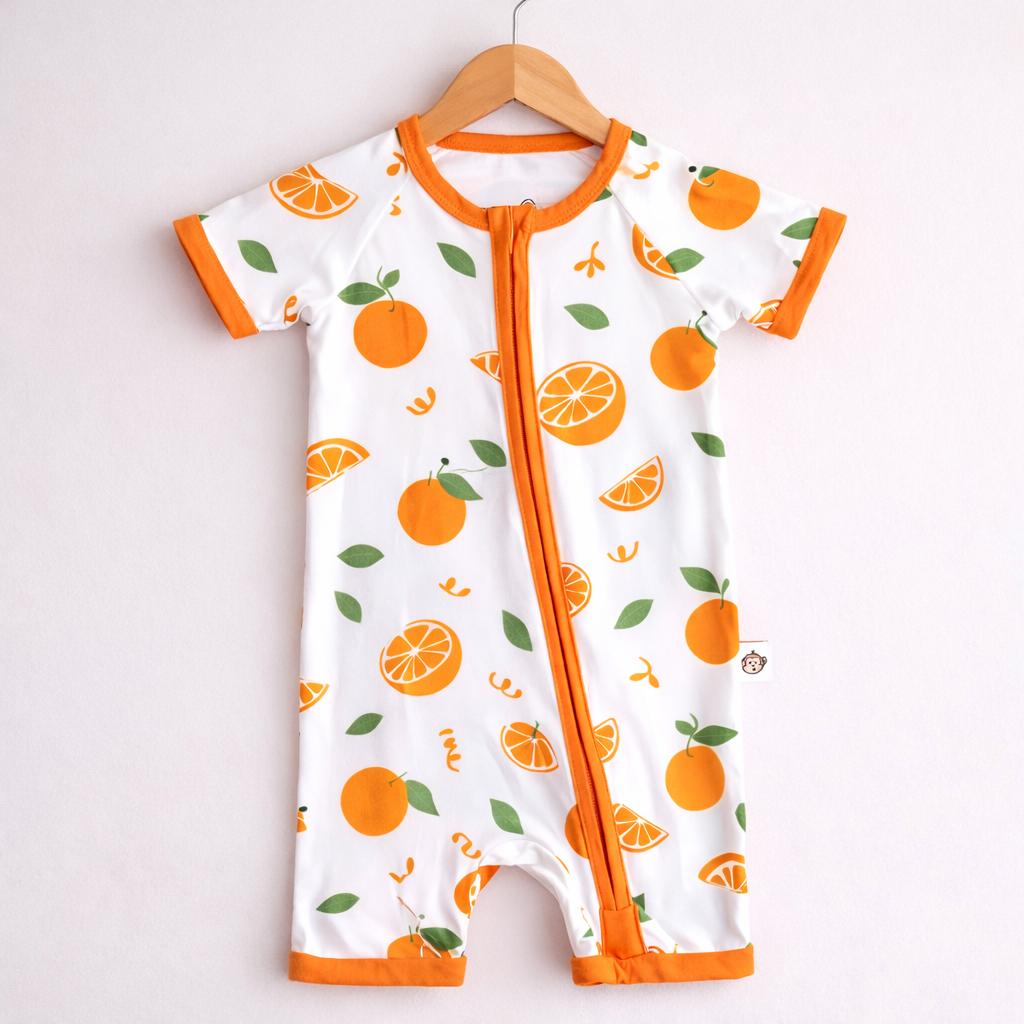 Baby onesie with orange pattern on a hanger against a white background