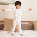 Child wearing a white bamboo pajama set with colorful patterns in a bedroom setting