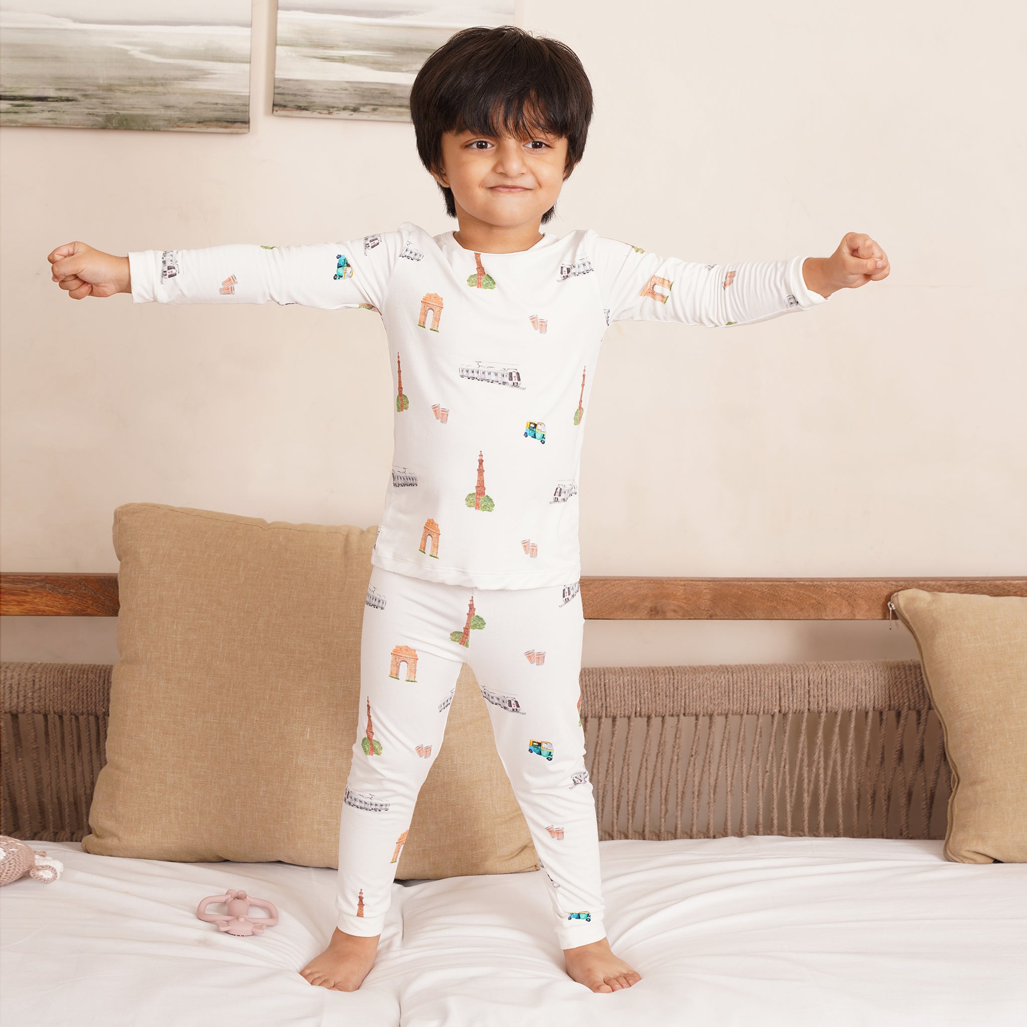 Child wearing a white bamboo pajama set with colorful patterns in a bedroom setting