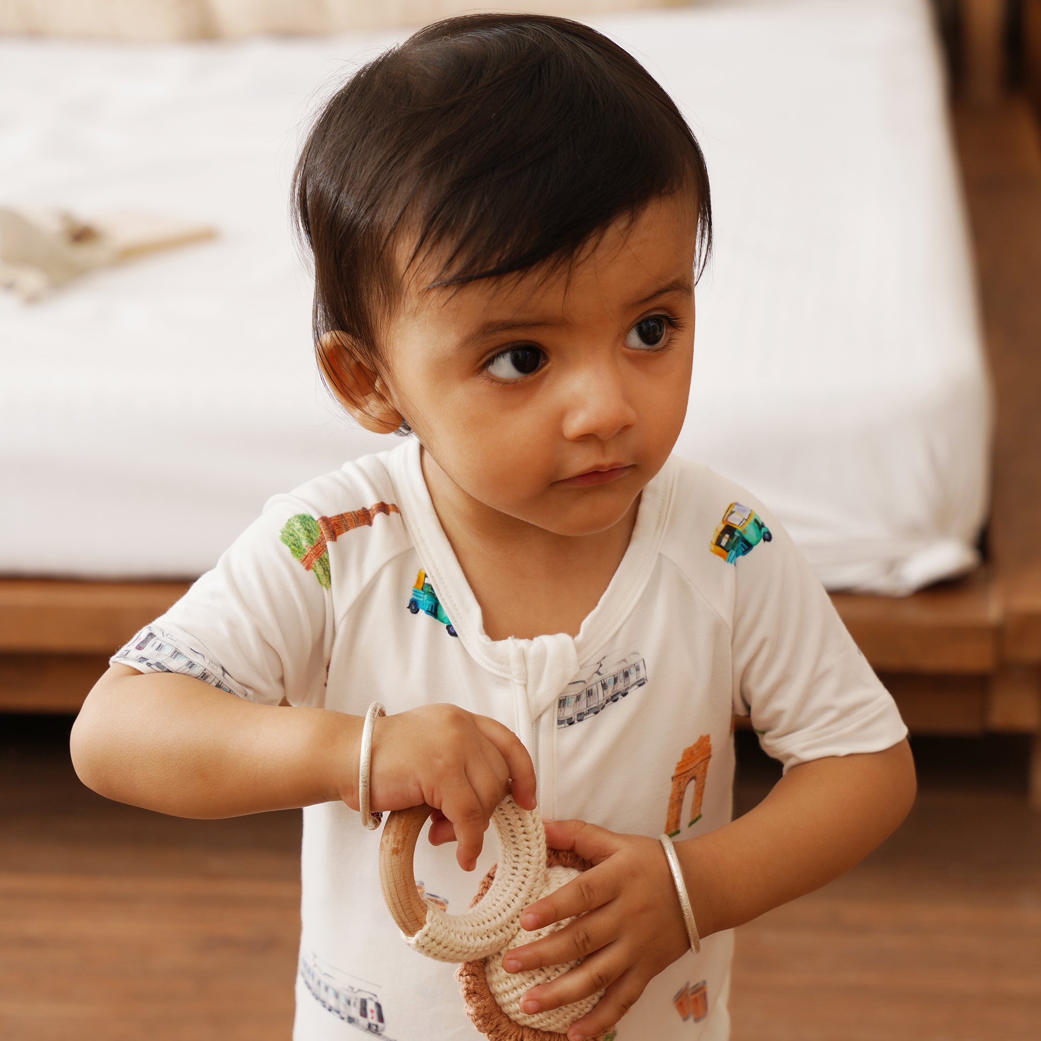 Toddler in a bamboo onesie with a rattle