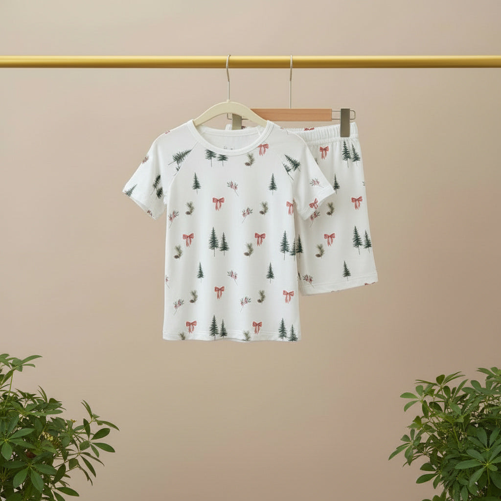 Children's t-shirt and shorts set with nature-themed print on a hanger against a beige background.