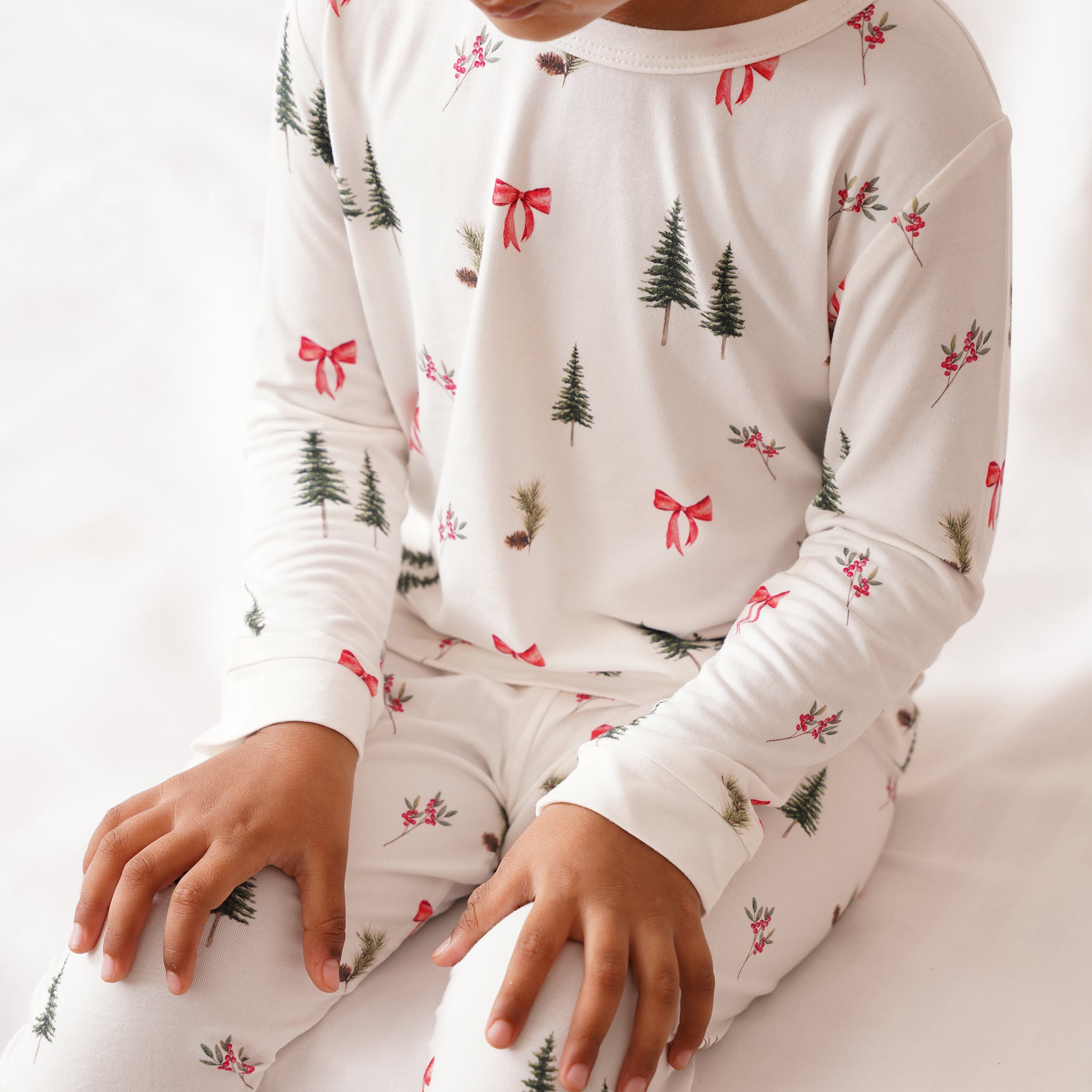 Children's bamboo pajama set with Christmas tree and bow pattern on a white background