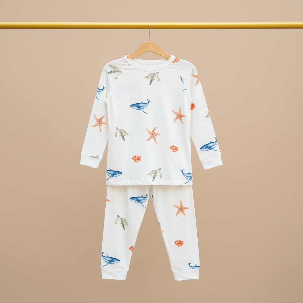 Children's pajama set with sea-themed design on a beige background