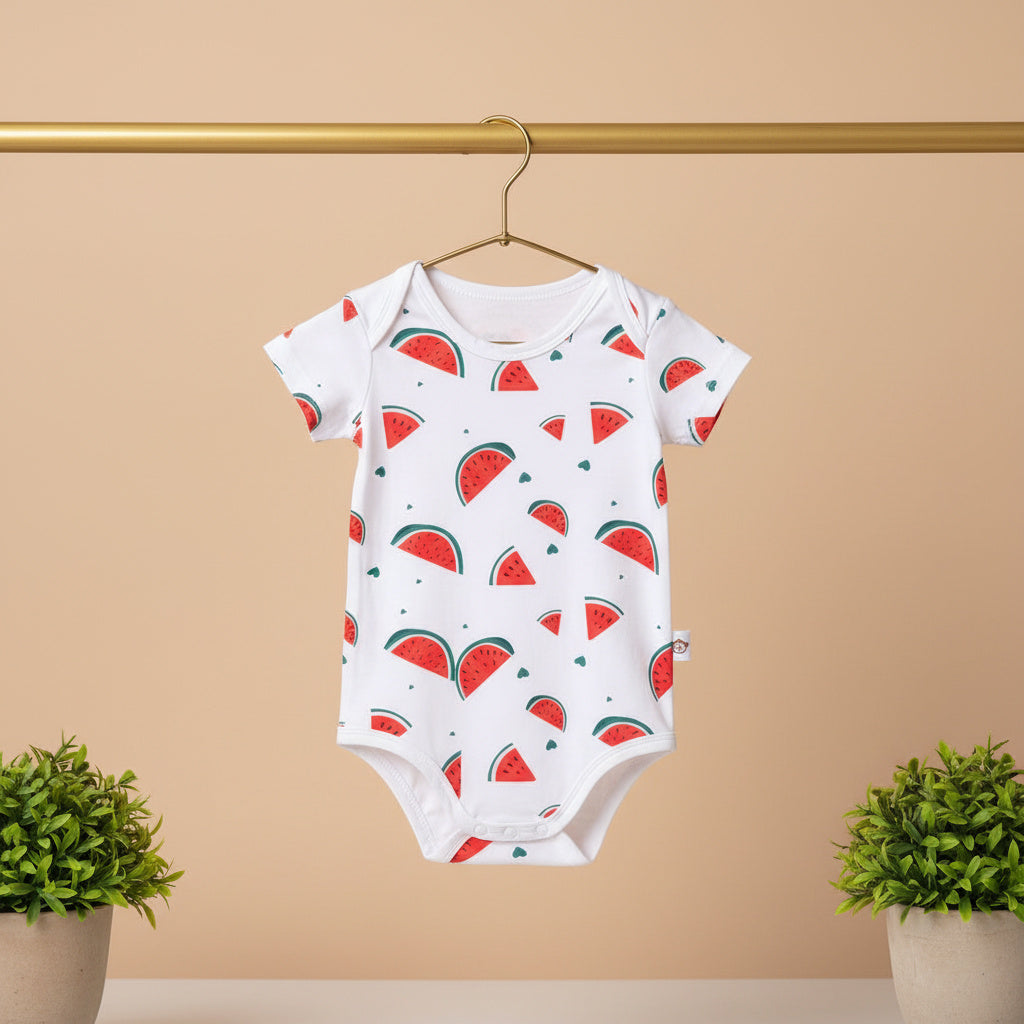 Baby onesie with watermelon pattern on a hanger against a beige background